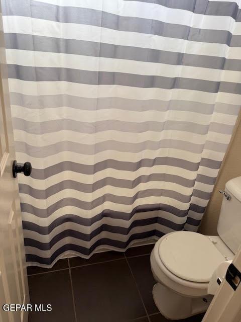 full bathroom featuring toilet and tile patterned flooring