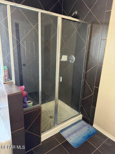 full bath with a shower stall and tile patterned floors