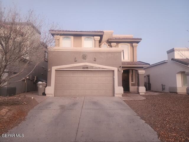 mediterranean / spanish-style house featuring driveway, a tiled roof, and stucco siding