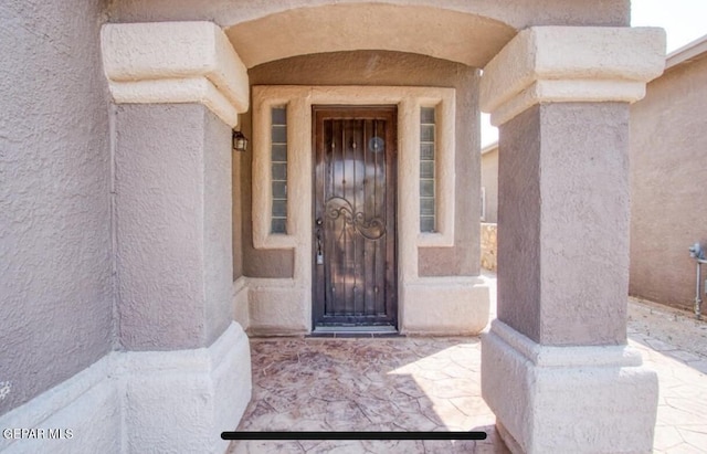 entrance to property featuring stucco siding