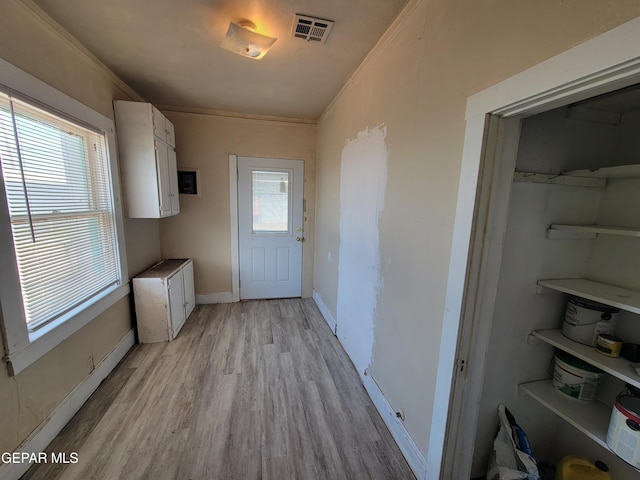 interior space featuring light wood-type flooring and crown molding