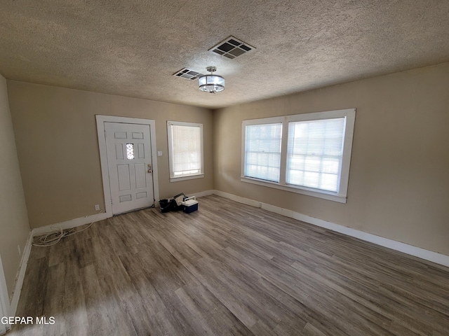 foyer with hardwood / wood-style flooring and a textured ceiling