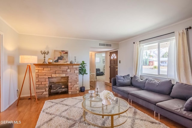 living room with a fireplace, light hardwood / wood-style floors, and ornamental molding