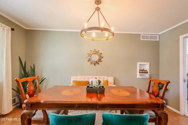 dining room with hardwood / wood-style floors, ornamental molding, and a notable chandelier