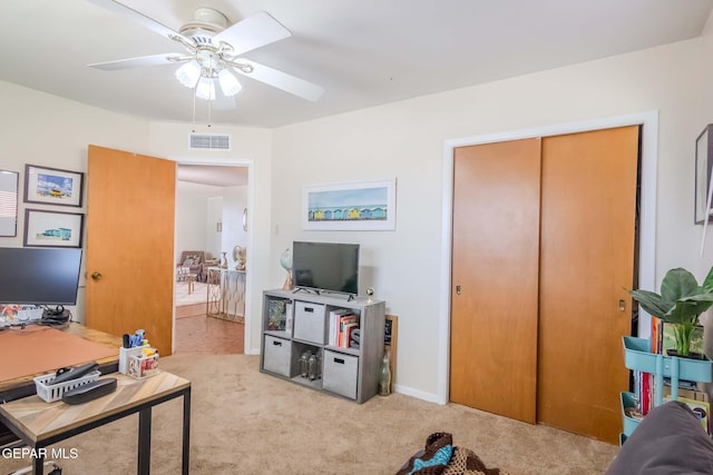 interior space featuring ceiling fan and light colored carpet