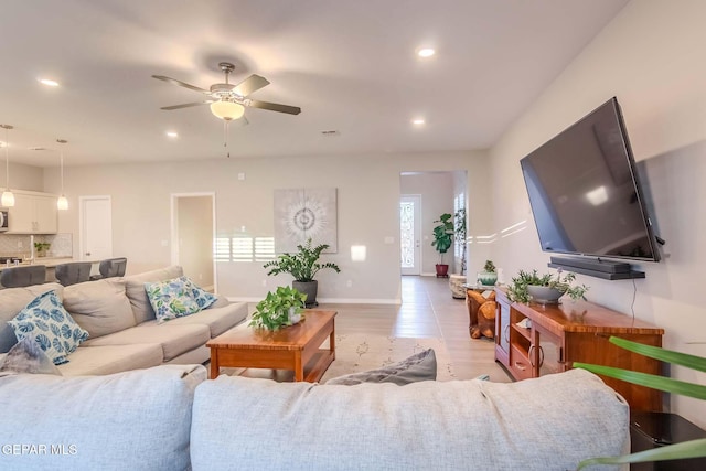 living room with ceiling fan and light wood-type flooring