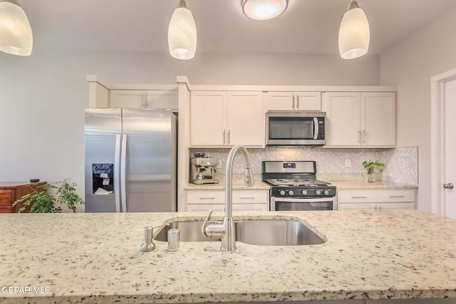 kitchen featuring stainless steel appliances, backsplash, pendant lighting, and sink