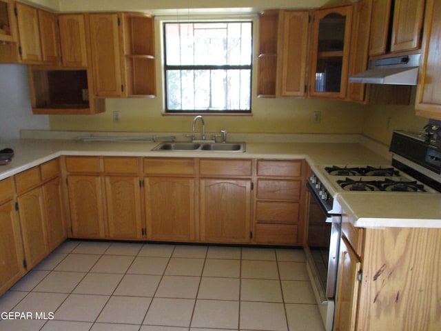 kitchen featuring white gas range, sink, and light tile patterned floors