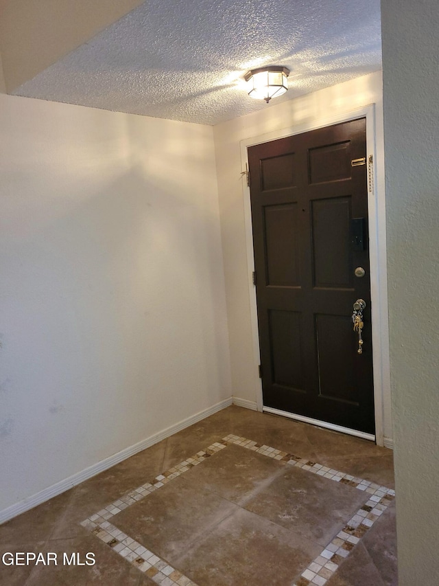 tiled foyer featuring a textured ceiling