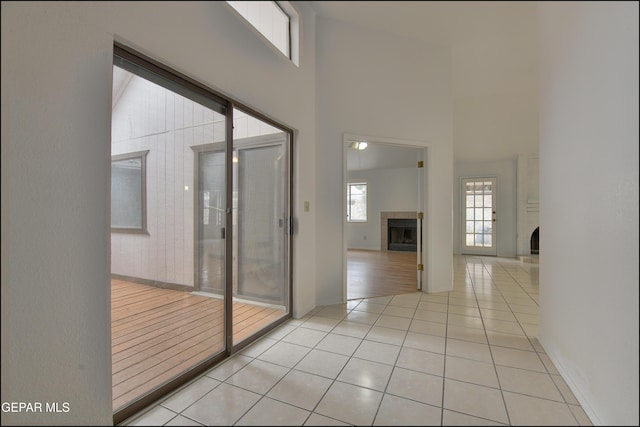 hallway with light tile patterned floors and a high ceiling