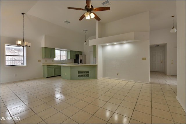 unfurnished living room with ceiling fan with notable chandelier, light tile patterned floors, and high vaulted ceiling