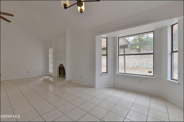 unfurnished living room with plenty of natural light, a large fireplace, and light tile patterned floors