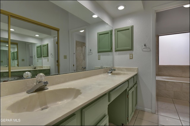 bathroom with a relaxing tiled tub, tile patterned floors, and vanity