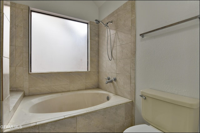 bathroom with tiled shower / bath combo and toilet