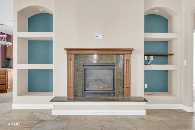 unfurnished living room featuring built in shelves and a fireplace