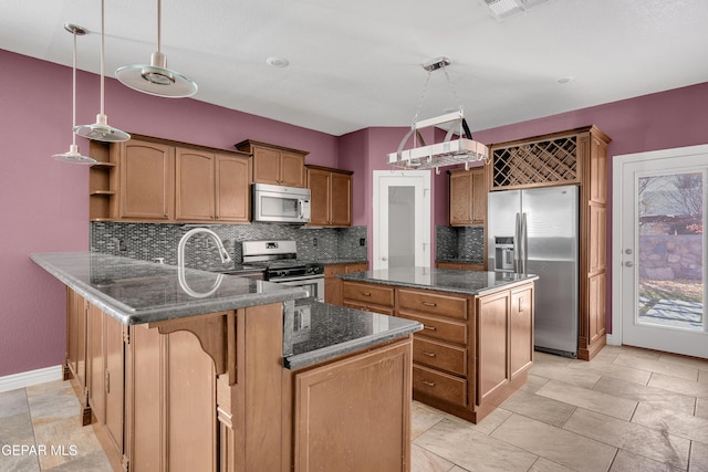 kitchen with kitchen peninsula, hanging light fixtures, stainless steel appliances, and sink