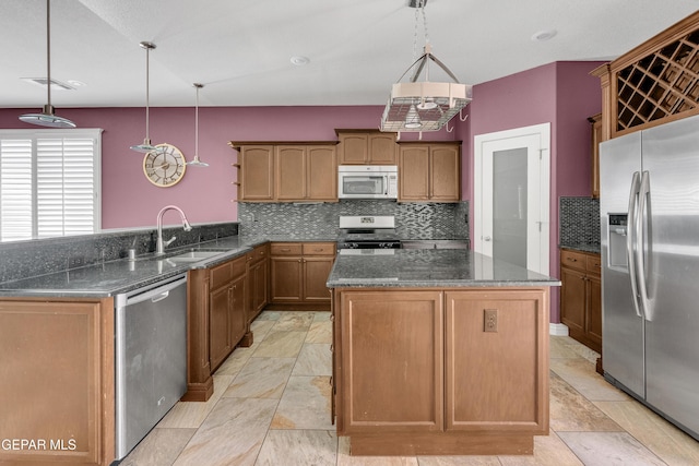 kitchen featuring kitchen peninsula, stainless steel appliances, hanging light fixtures, and sink