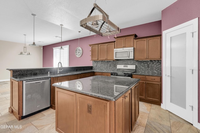 kitchen with sink, hanging light fixtures, stainless steel dishwasher, gas stove, and kitchen peninsula