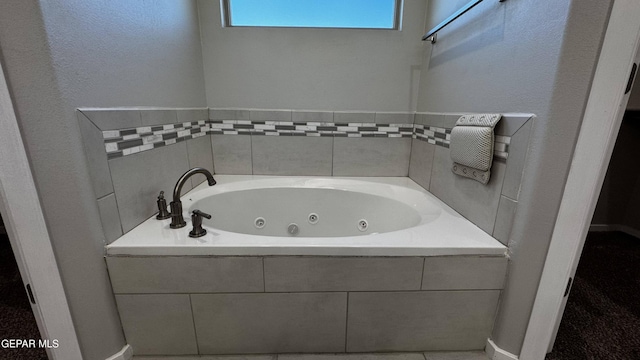 bathroom with tile patterned flooring and a relaxing tiled tub