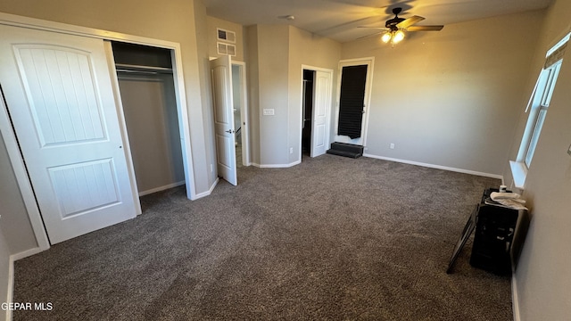 unfurnished bedroom with dark colored carpet and ceiling fan