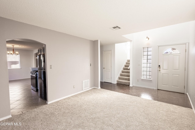 interior space with dark tile patterned floors and an inviting chandelier