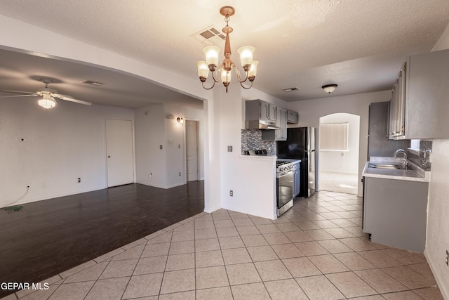 kitchen with backsplash, ceiling fan with notable chandelier, sink, stainless steel range oven, and gray cabinets