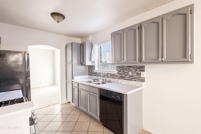 kitchen with light carpet, decorative backsplash, sink, black appliances, and gray cabinets