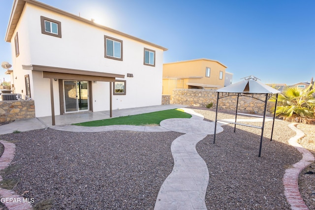 rear view of house with cooling unit and a patio