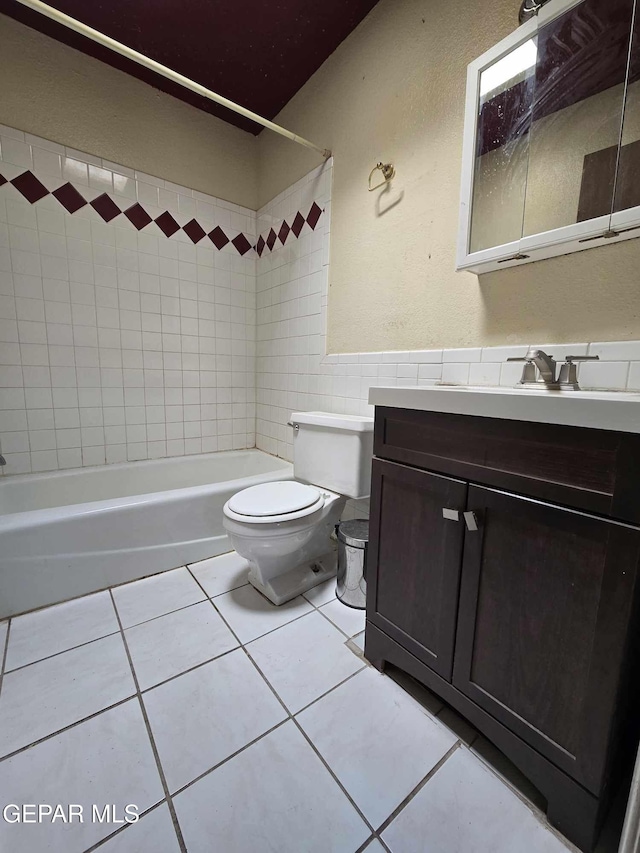 full bathroom with tile patterned floors, vanity, toilet, and tiled shower / bath combo