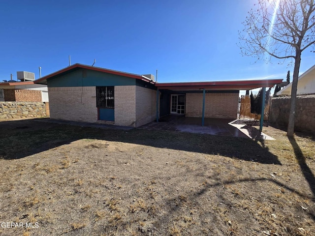 rear view of property with central air condition unit and a patio area