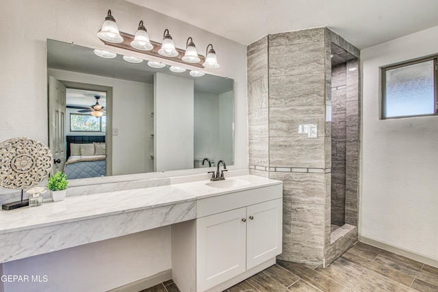 bathroom featuring a tile shower, ceiling fan, and vanity