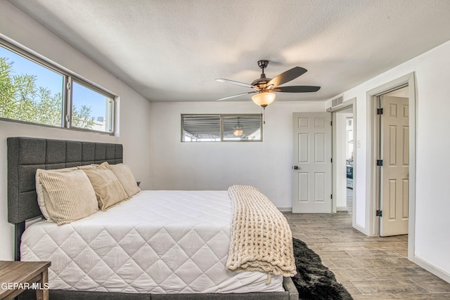 bedroom featuring ceiling fan and a textured ceiling