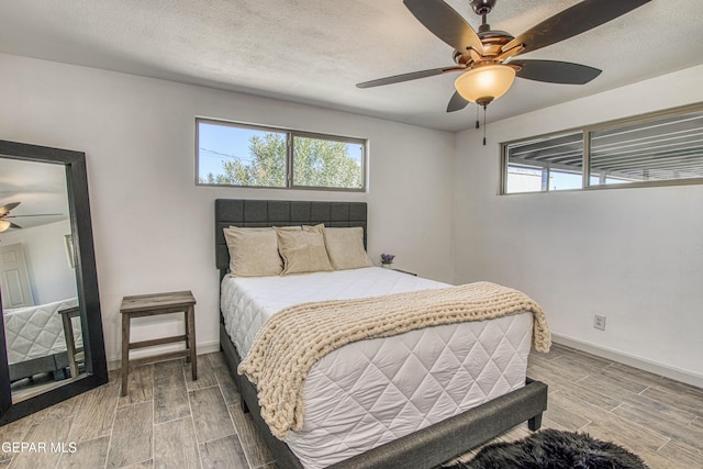 bedroom with ceiling fan and a textured ceiling