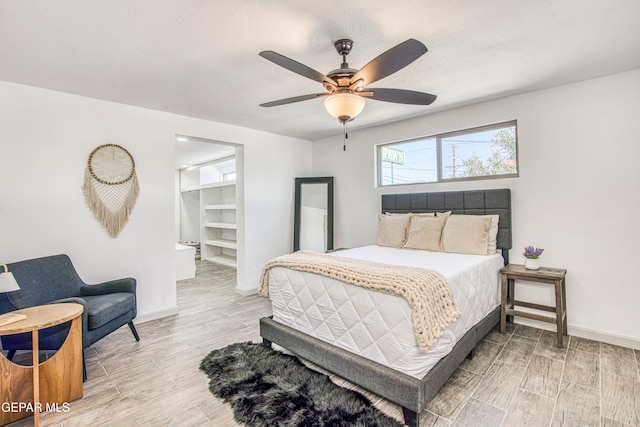 bedroom with ceiling fan, wood-type flooring, a spacious closet, and a closet