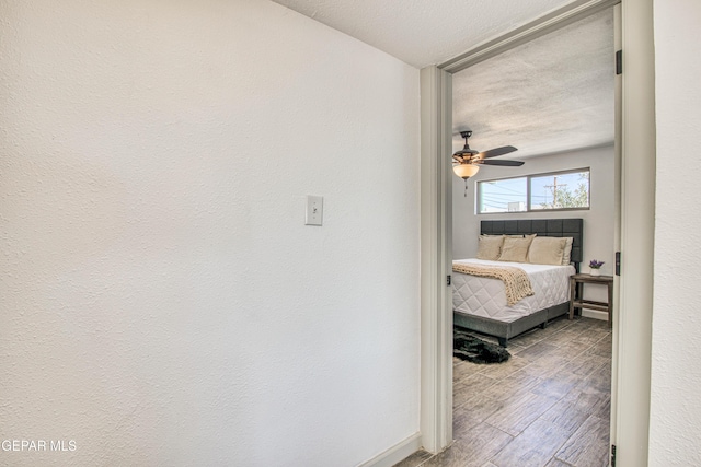 corridor featuring a textured ceiling and light hardwood / wood-style flooring