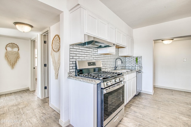 kitchen featuring white cabinetry, sink, extractor fan, decorative backsplash, and appliances with stainless steel finishes