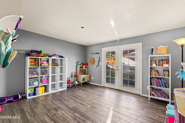 recreation room featuring a textured ceiling, french doors, and wood-type flooring