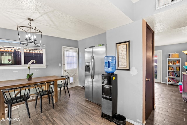 kitchen with a notable chandelier, stainless steel fridge with ice dispenser, dark hardwood / wood-style flooring, and a textured ceiling