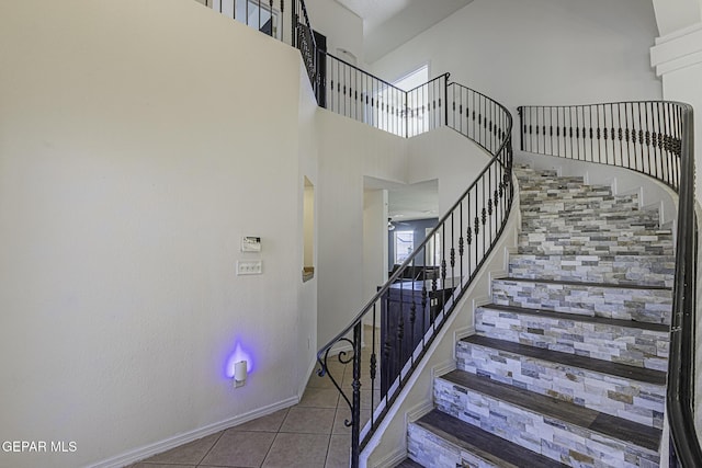 stairs featuring a high ceiling and tile patterned flooring