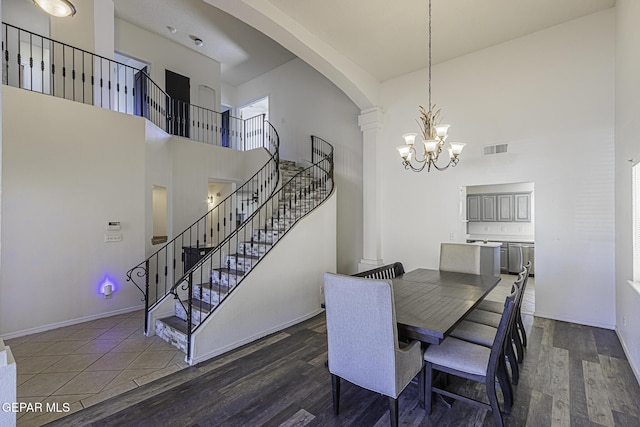 dining area with a high ceiling, an inviting chandelier, and dark hardwood / wood-style floors