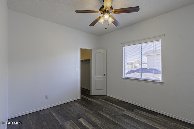 unfurnished room featuring a textured ceiling, ceiling fan, and dark hardwood / wood-style floors