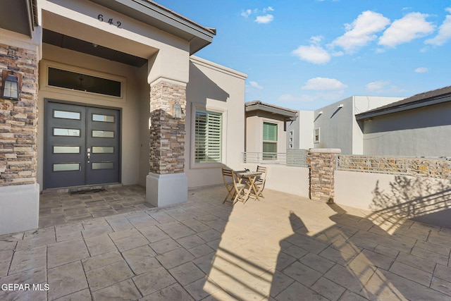 view of exterior entry featuring a patio area