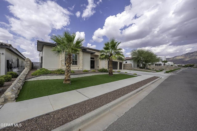 view of front of property with a front lawn, a garage, and a mountain view