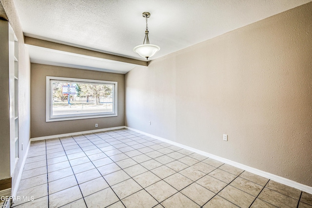 tiled empty room with a textured ceiling