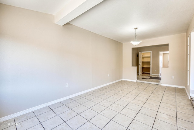 tiled spare room featuring beamed ceiling