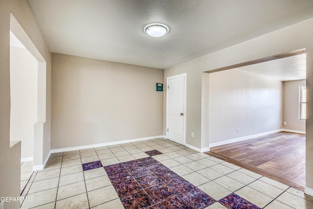 empty room with light tile patterned floors and a textured ceiling