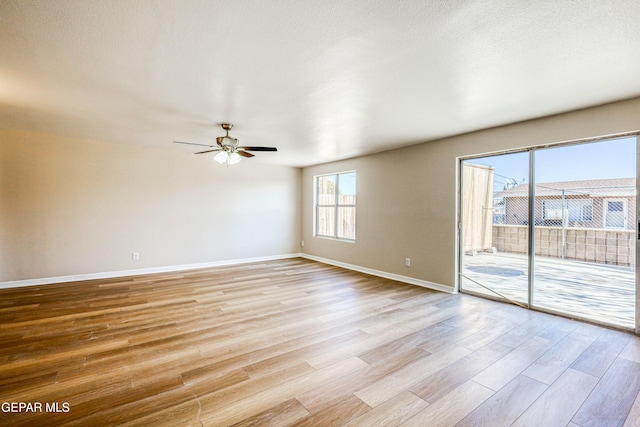 empty room with ceiling fan and light hardwood / wood-style floors