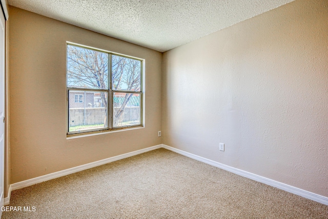 carpeted empty room with a textured ceiling