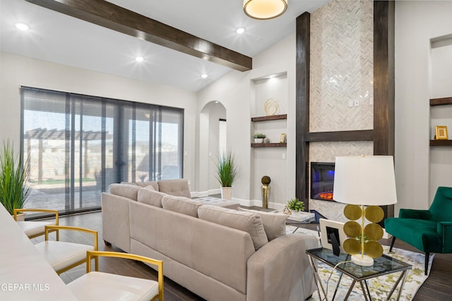 living room with built in shelves, vaulted ceiling, hardwood / wood-style floors, and a fireplace