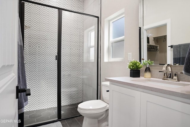 bathroom with vanity, a wealth of natural light, tile patterned floors, and a shower with door